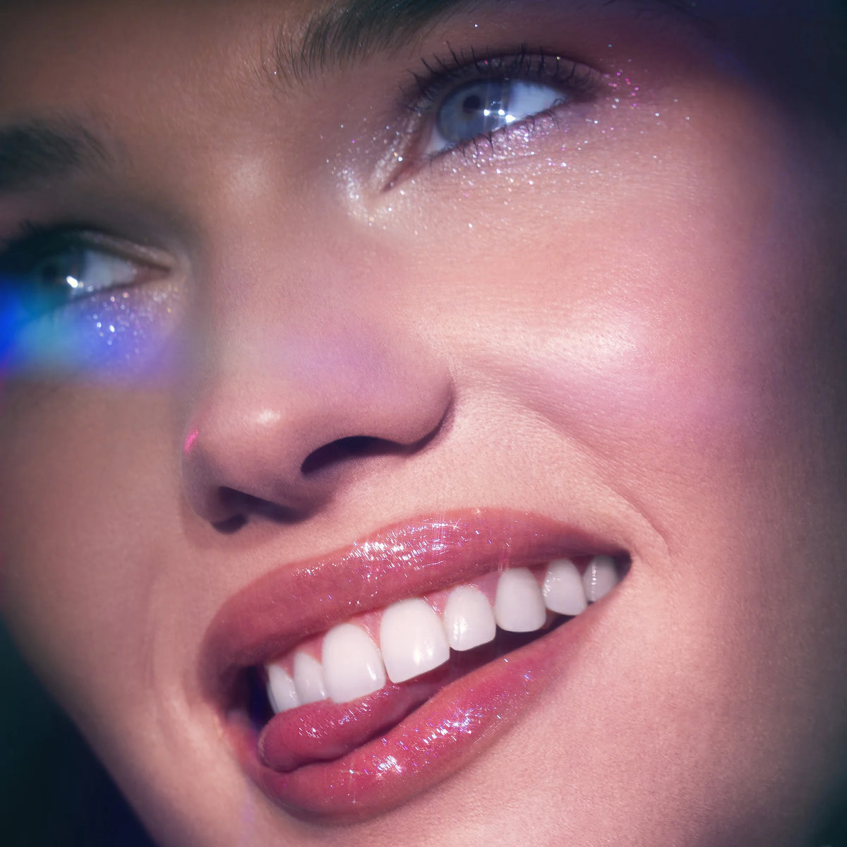 AuraLab E.L.F. Glow Reviver Lip Oil Glimmer in Candy Coded, showing the clear lip oil with shimmering gloss in a small bottle.