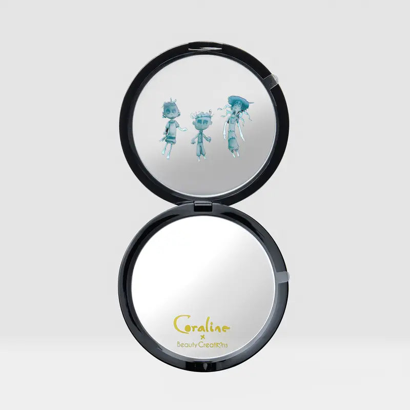 Beauty Creations Coraline Button Eyes Compact Mirror with unique button-eye design and cartoon characters inside.